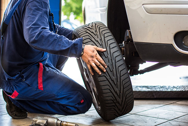 auto body shop montreal alloy wheel mag repair technician remove tire from car
